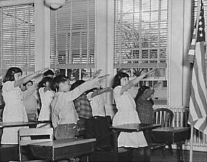 students reciting the pledge of allegiance with the Bellamy salute